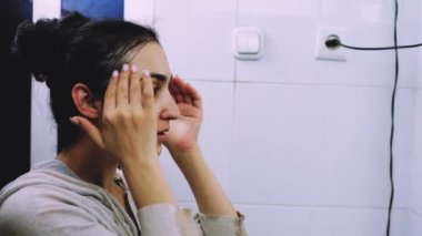 Banyoda makyaj maskesi takan bir kadın. Karışık ırk dişileri yüzüne beyaz besleyici maske ya da krem sürerler. Yüzüne maske takıyorum. Cilt temizleme spa rahatlama konsepti