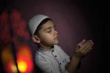 Müslüman çocuk camide namaz kılıyor. Küçük ortadoğulu çocuk Tanrı 'ya dua ediyor ve teşekkürler. Kutsal Ramazan ayında barış ve sevgi