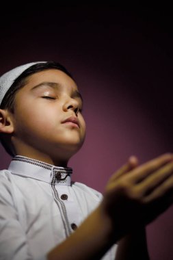 Müslüman çocuk camide namaz kılıyor. Küçük ortadoğulu çocuk Tanrı 'ya dua ediyor ve teşekkürler. Kutsal Ramazan ayında barış ve sevgi