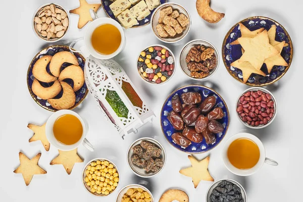 Traditional Ramadan dinner on pure white table. Traditional middle-eastern lunch with cookies and sweets. Ramazan Iftar food - meal Muslims eat after sunset during Ramadan. Top view