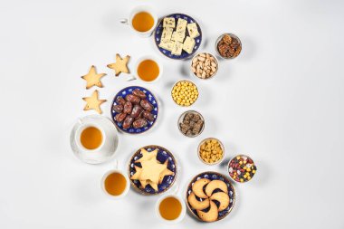 Saf beyaz masada geleneksel Ramazan yemeği. Geleneksel Orta Doğu yemeği, kurabiye ve şekerli. Ramazan iftar yemeği - Müslümanların Ramazan 'da günbatımından sonra yediği yemek. Üst görünüm