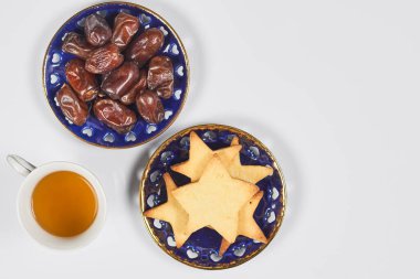 Saf beyaz masada geleneksel Ramazan yemeği. Geleneksel Orta Doğu yemeği, kurabiyeler ve kuru hurma meyveleri. Ramazan iftar yemeği - Müslümanların Ramazan 'da gün batımından sonra yediği yemek