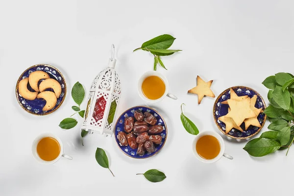 Traditional Ramadan dinner on pure white table. Traditional middle-eastern lunch with cookies and sweets. Ramazan Iftar food - meal Muslims eat after sunset during Ramadan. Top view