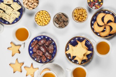 Saf beyaz masada geleneksel Ramazan yemeği. Geleneksel Orta Doğu yemeği, kurabiye ve şekerli. Ramazan iftar yemeği - Müslümanların Ramazan 'da günbatımından sonra yediği yemek. Üst görünüm