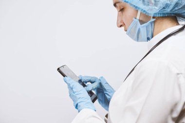 Mola sırasında cep telefonu kullanan kadın doktor. İnternet taranıyor, haber, e-posta ve sohbet mesajları kontrol ediliyor
