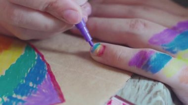 Gurur günü. Tırnaklarına gökkuşağı bayrağı çizen bir kadın. LGBTQ tarzı tırnak sanatı ve vücut sanatı. 2020 Onur Festivali. İnsan hakları, cinsiyet eşitliği kavramları