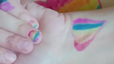 Gurur günü. Tırnaklarına gökkuşağı bayrağı çizen bir kadın. LGBTQ tarzı tırnak sanatı ve vücut sanatı. 2020 Onur Festivali. İnsan hakları, cinsiyet eşitliği kavramları