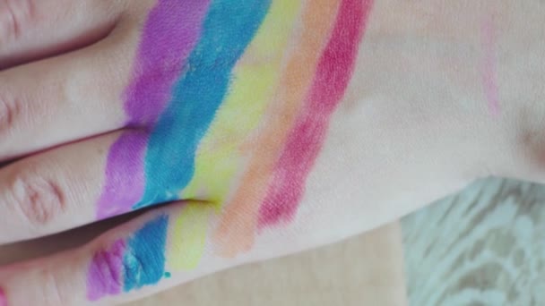 Jour de la fierté. Femme dessinant un drapeau arc-en-ciel sur ses ongles. Style LGBTQ nail art et body art. Festival Fierté 2020. Droits de l'homme, concepts d'égalité des sexes 