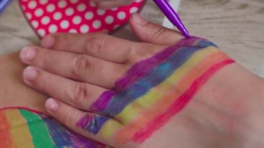 Gurur günü. Kadın el bileğine gökkuşağı bayrağı çiziyor. LGBTQ tarzı vücut sanatı. 2020 Onur Festivali. İnsan hakları, cinsiyet eşitliği kavramları