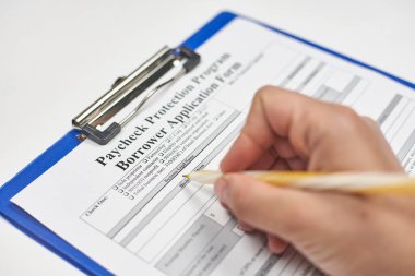 Başvuru formu dolduran bir kişi. Uygun bir borç veren ile Maaş Koruma Programına başvurun