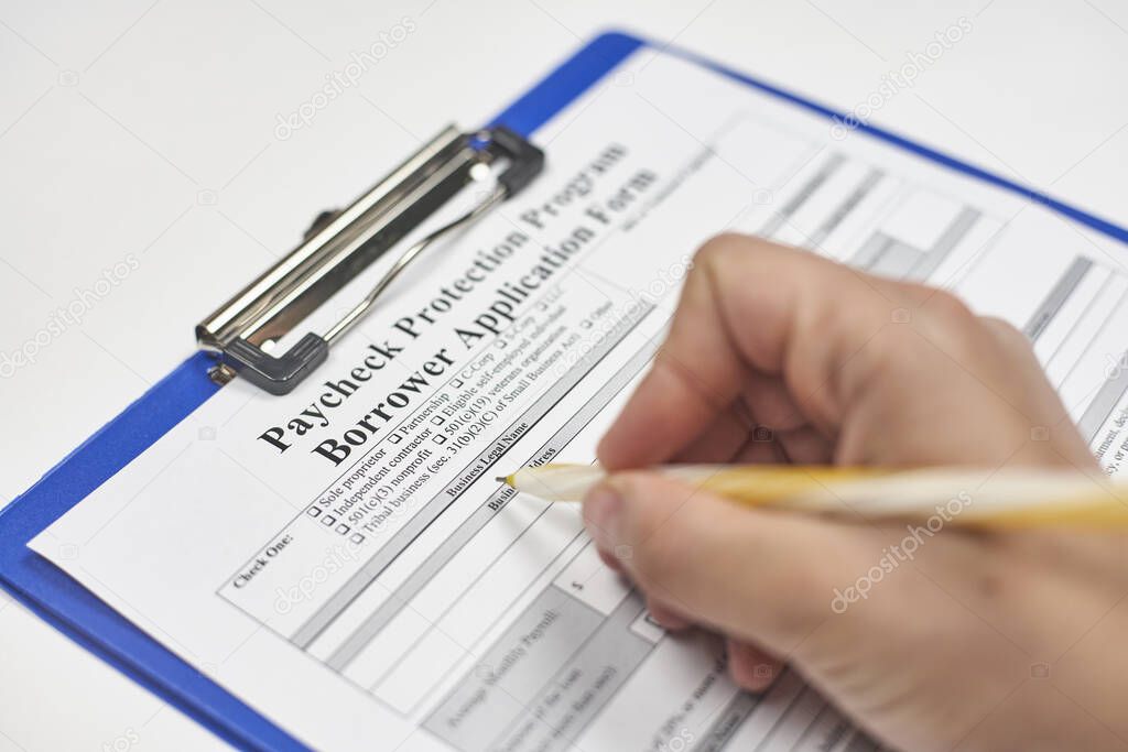 A person filling application form. Apply for the Paycheck Protection Program with an eligible lender