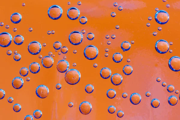 Gruppe von orangen und blauen Luftblasen im Wasser — Stockfoto