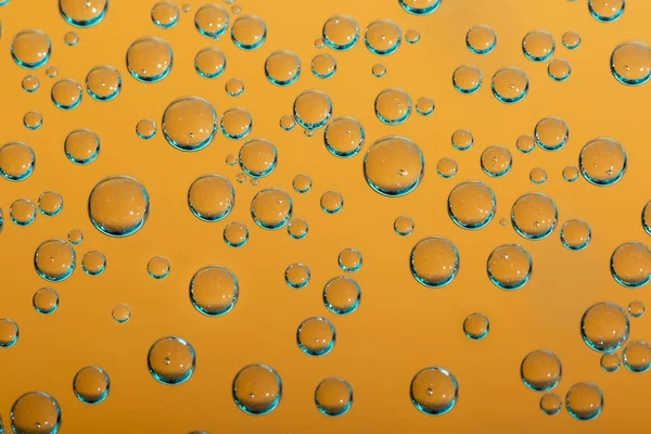 Gruppe von orangen und blauen Luftblasen im Wasser — Stockfoto