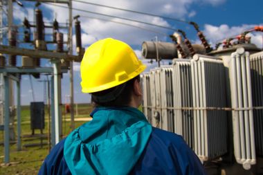 Sarı kask ile teknisyen incelemek yüksek gerilim elektrik santrali