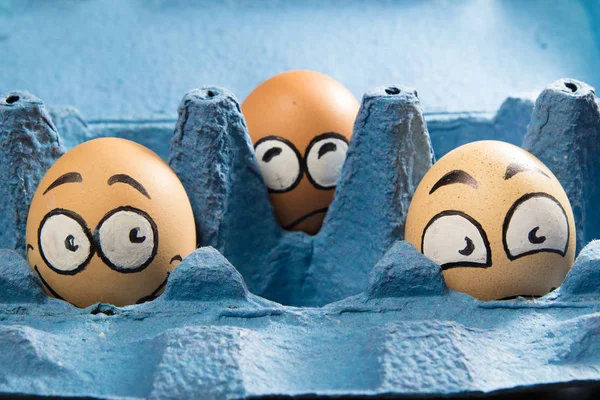 Trzy twarze przestraszony jajko w panelu niebieski — Zdjęcie stockowe