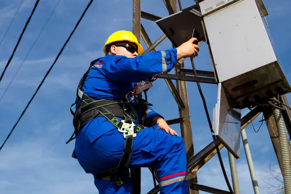 Ingeniero tomando fotos en el poste de luz con teléfono inteligente — Foto de Stock