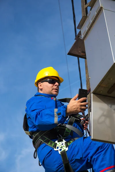 Electricista tomando fotos en el poste de luz con teléfono inteligente — Foto de Stock
