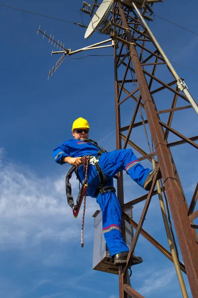 Elektriker mit Sicherheitsgurt klettert auf Strommast — Stockfoto