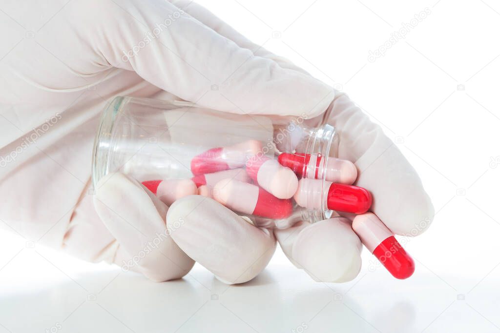 A white-gloved man opens a glass bottle of antibiotics