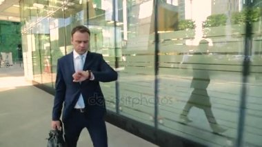 Acele, takım elbiseli Merhaba işadamıdır geç, bakarak. Steadicam atış.