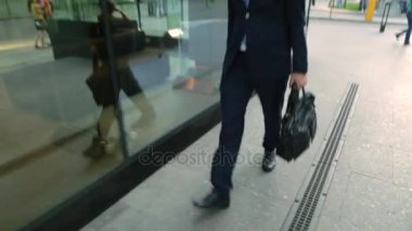 Mutlu işadamı ile sokakta yürürken bir takım elbise. Steadicam atış.