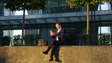 Gülüyor, gülüyor sokakta, tablet bilgisayar kullanarak yakışıklı işadamı