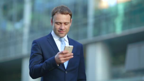 Atractivo hombre de negocios que utiliza la aplicación en el teléfono inteligente — Vídeo de stock