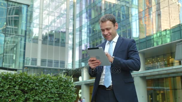 Hombre de negocios guapo usando Tablet PC en la calle — Vídeo de stock