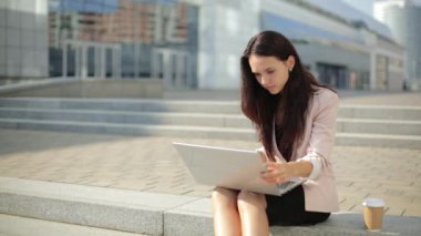 Güzel kız sokakta, dizüstü kullanarak çalışkan