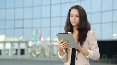 Güzel kız sokakta tablet bilgisayar kullanarak