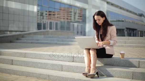 Pretty girl using laptop on the street, working hard — Stock Video