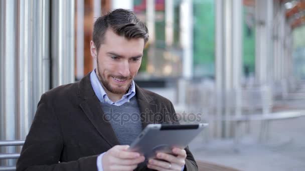 Pohledný muž pomocí tabletový počítač poblíž moderní obchodní centrum, mrakodrap, Mall — Stock video