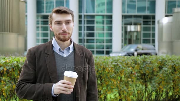 Hombre atractivo bebiendo café o té de taza de papel, sonriendo — Vídeos de Stock