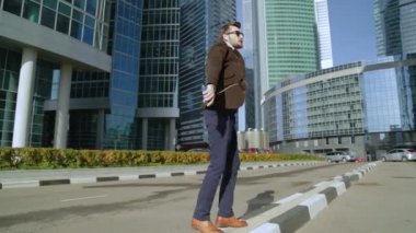 Yakışıklı adam akıllı telefon kulaklık müzik dinlemek ve gökdelenler dans