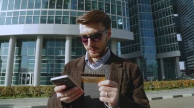 Çekici bir adam akıllı sokakta kredi kartı ile online banka kullanarak