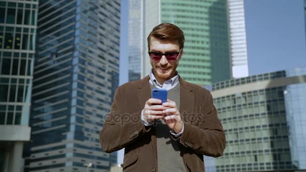 Atraktivní muž pomocí aplikace na chytrém telefonu, s úsměvem — Stock video