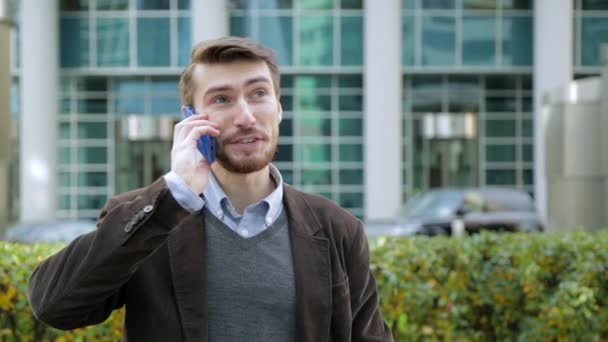 Homem atraente em um terno falando ao telefone na rua — Vídeo de Stock