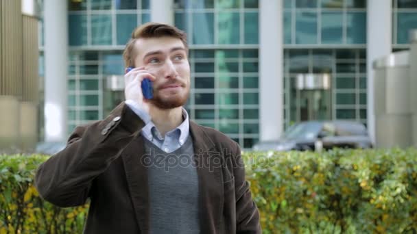 Homme attrayant dans un costume parlant au téléphone dans la rue — Video