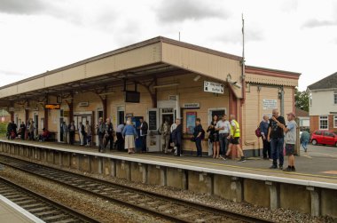Warminster, İngiltere - 17 Ağustos 2019: Warminster, Wiltshire 'da bulutlu bir yaz öğleden sonrasında tren bekleyen yolcular. 