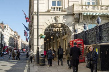 LONDON, İngiltere - 28 Ocak 2016: Piccadilly, Londra 'da güneşli bir kış öğleden sonrasında Ritz Hotel atari salonunda yayalar ve trafik.