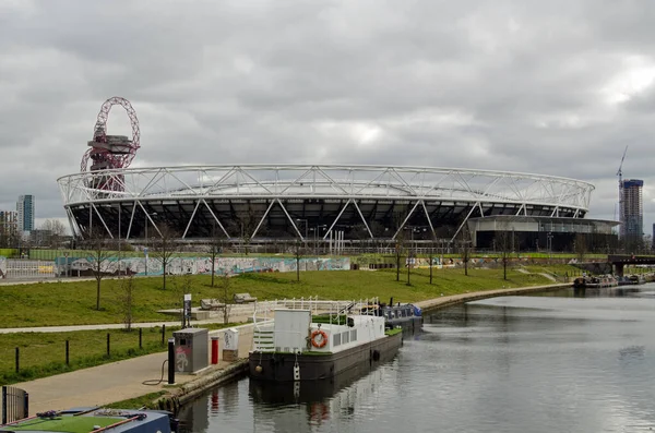 Daha önce Londra 2012 Olimpiyatları 'nda kullanılan Queen Elizabeth Park' taki West Ham United Stadyumu. Yörünge kulesi arkada, Lee Navigasyon kanalı da sağda. Mart 'ta bulutlu bir öğleden sonra.