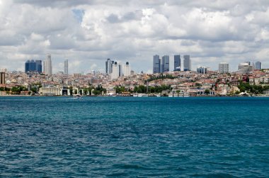 İSTANBUL, TURKEY - 8 Haziran 2016: Bulutlu bir yaz gününde İstanbul 'un Beşiktaş ilçesine doğru İstanbul Boğazı' nı gezin. Sahil şeridi boyunca Bahçeşehir Üniversitesi var. 