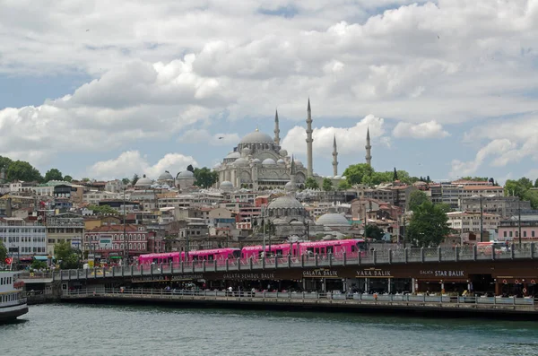 İSTANBUL, TURKEY - 8 Haziran 2016: İstanbul, Türkiye 'deki ünlü Galata Köprüsü' nden pembe renkli bir tramvay geçiyor. Ufuk çizgisine Süleyman Camii hakim..