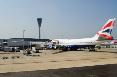 LONDON, İngiltere - 9 Haziran 2016: Güneşli bir yaz sabahı Londra Heathrow Havaalanı Terminali 5 'teki stantta İngiliz Havayolları jumbo jeti.  