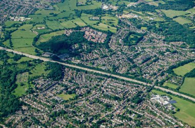 M25 otoyolu ile Surrey 'deki Addlestone' un havadan görünüşü Row Town ile yerleşim alanlarını ikiye bölüyor. Sol alt köşede Jubilee Lisesi ve sol üstte Hayvan ve Bitki Sağlığı Ajansı var.