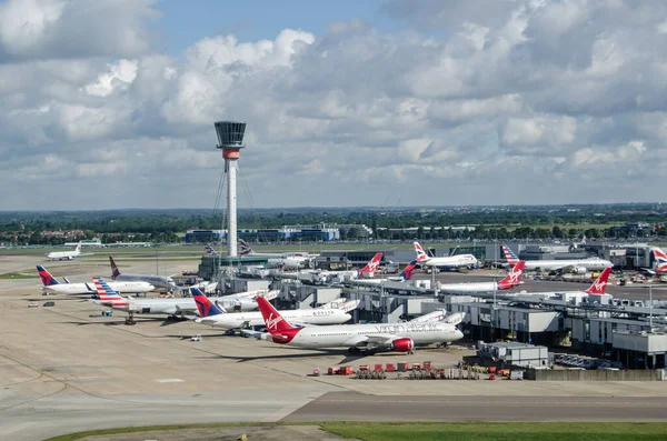 LONDON, İngiltere - 3 Haziran 2017: Güneşli bir yaz sabahı, Londra 'nın Heathrow Havaalanı' nın 3 numaralı terminalinde parkedilmiş uçakların görüntüsü. Virgin Atlantic, Delta ve American Airlines 'ın hepsi yoğun havaalanının bu bölümünü kullanıyor.. 