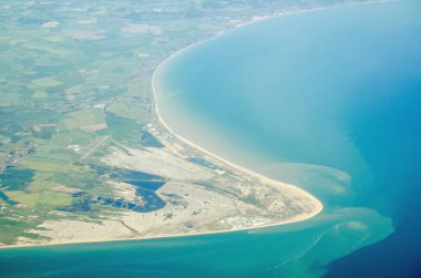 Dungeness Burnu 'nun Kent, İngiltere' deki İngiliz Kanalı 'na girdiği hava görüntüsü. Dibe doğru Dungeness nükleer enerji santrali ve solda Londra Ashford Havaalanı var..