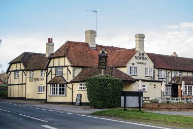 HECKFIELD, İngiltere - 10 Mart 2019: tarihi koçluk hanının görüntüsü - New Inn, Heckfield ana Odiham 'dan Reading Road in Hampshire. Tudor zamanlarına dayanan Inn, yiyecek, içecek ve konaklama olanakları sunuyor. Güneşli bahar öğleden sonra.