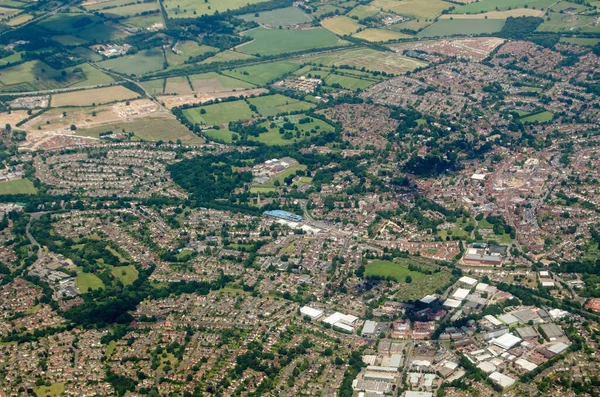 Aerial view of the Berkshire town of Wokingham, seen on a sunny summer day.  The blue structure of the railway station\'s multi-story car park is at the centre of the image with the A329(M) road cutting across the top.
