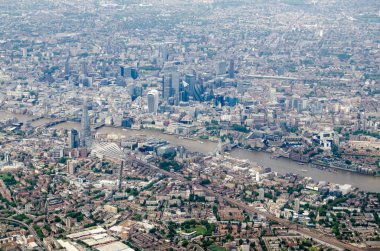 Thames Nehri 'nin Tower Bridge' in altından aktığı Southwark ve Londra şehrinin havadan görünüşü ve Çömlek, Gherkin ve Barbican 'ın kule blokları görünür. Güney Doğu 'dan Londra Köprü İstasyonu' nun demiryolu istasyonuna doğru bakın.